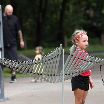 Young child plays on Sound Garden instrument.