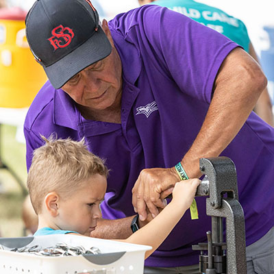 Artyopolis Volunteer assists child with button making, Photo: Tanner Colvin